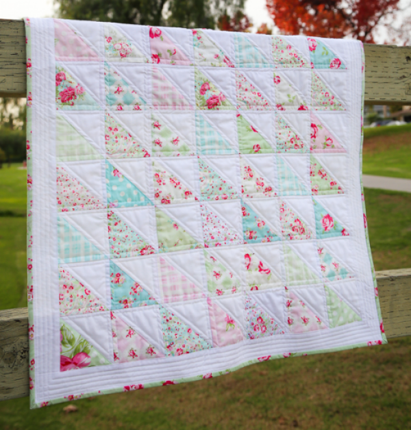 "Rosey Half Square Triangle Quilt" is a Free Charm Pack Lap Quilt Pattern designed by Susie from Loganberry Handmade! Brought to you by BOMquilts.com!